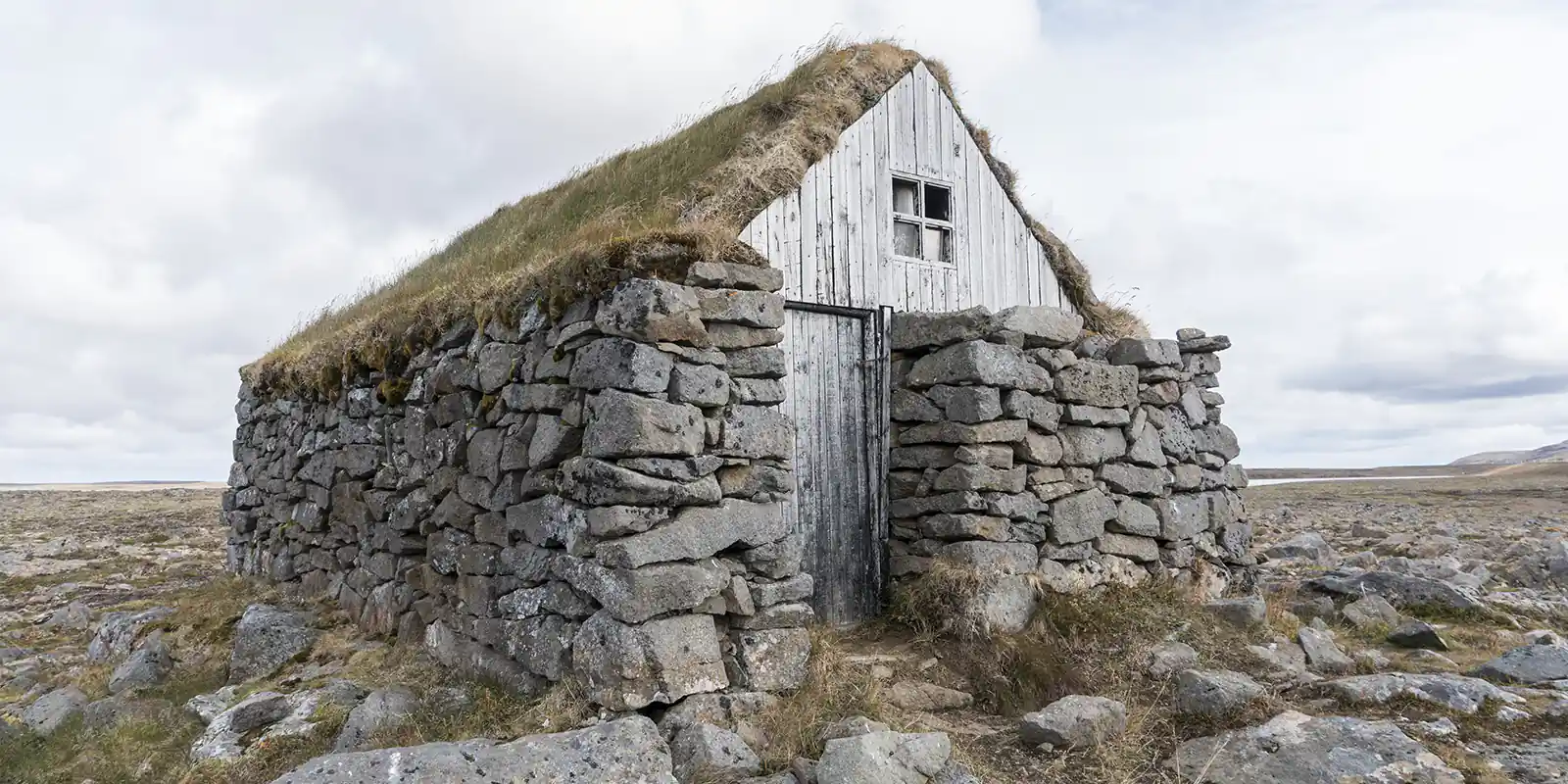 Una solitaria casa de turba se alza orgullosa entre las fortificaciones rocosas